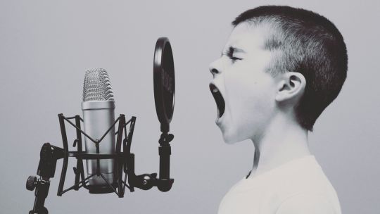 Ein Kind schreit in eine Mikrofon
