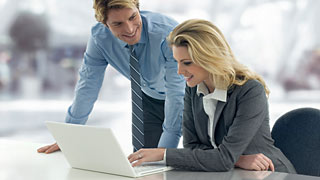 Woman and man in front of a laptop