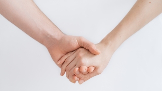Zwei Menschen halten sich an der Hand