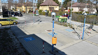 Blick von oben auf 3 Behinderten-Parkpltze vor dem Donaustdter Bad