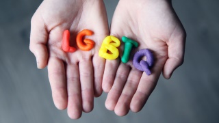 Handinnenflchen, auf denen die Buchstaben LGBTQ in Knetmasse liegen