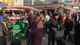 Mehrere Personen gehen am Markt einkaufen