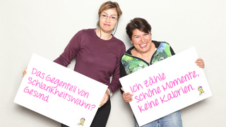 Zwei Frauen halten Schilder mit positiven Aufschriften zum Thema Krpernorm