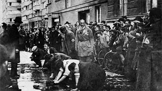 To the acclaim of numerous bystanders, Jews are forced to wash the roads