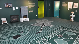 Exhibition room with carpets and stoves.