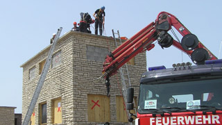 Feuerwehrmnner bei einem Einsatz auf einem Dach