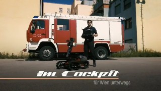Ein Mann steht mit einem Taurob vor einem Feuerwehrauto, mit Schriftzug