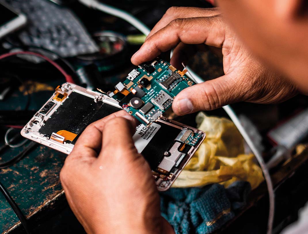 Mann repariert ein elektronisches Gerät. 