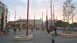 Christian-Broda-Platz aus der Fugngerperspektive mit den markanten roten Stelen und runden Sitzelementen aus Beton