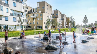 Wasserspielplatz mit Kindern in einem Neubaugebiet