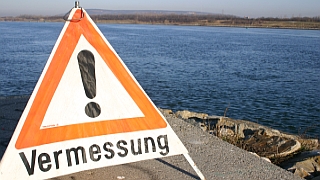 Warndreieck Achtung Vermessung aufgestellt am Donauufer.