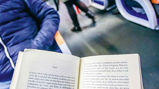 Ein offenes Buch als Reiselektre in der Schnellbahn.