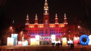 Rathaus bei Nacht, bunt beleuchtet mit Eisflche am Platz