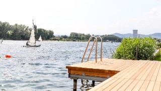 Badesteg an der Alten Donau mit Segler im Hintergrund
