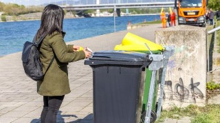 Frau benutzt eine der neuen Mlltonnen auf der Donauinsel