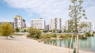 Teich mit modernen Wohnbauten im Hintergrund