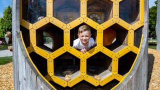 Bub in einem Spielplatzgert in Form einer Bienenwabe