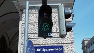 Green pedestrian traffic lights displaying two men who hold hands, a heart as symbol between them