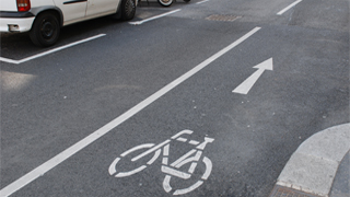 Fahrradpiktogramm mit Richtungspfeil auf markiertem Radweg