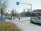 Kreuzungsbereich Grinzinger Strae - Bereich Schule: Strae mit rot unterlegtem Zebrastreifen und einem Schlerlotsen