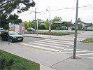 Kreuzungsbereich Neilreichgasse - Nebenfahrbahn: Breite Kreuzung mit Zebrastreifen ber eine Nebenfahrbahn, Verkehrsinseln und Straenbahnschienen