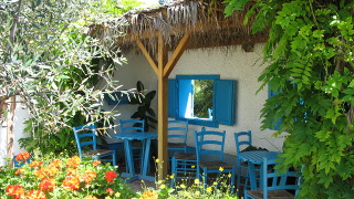 Greek garden with blue tables and chairs