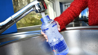 Eine Wasserflasche wird mit Leitungswasser angefllt