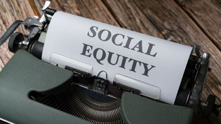 Schreibmaschine mit einem eingespannten Blatt, auf dem "Soziale Gleichheit" steht