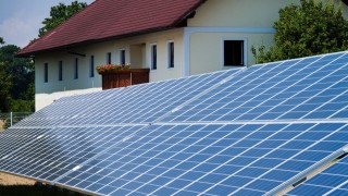 Solarzellen vor einem Wohnhaus