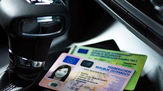 Vozačka i saobraćajna dozvola pored menjača u autu.