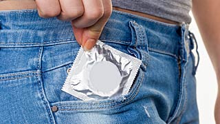 Žena stavlja kondom u džep od pantalona