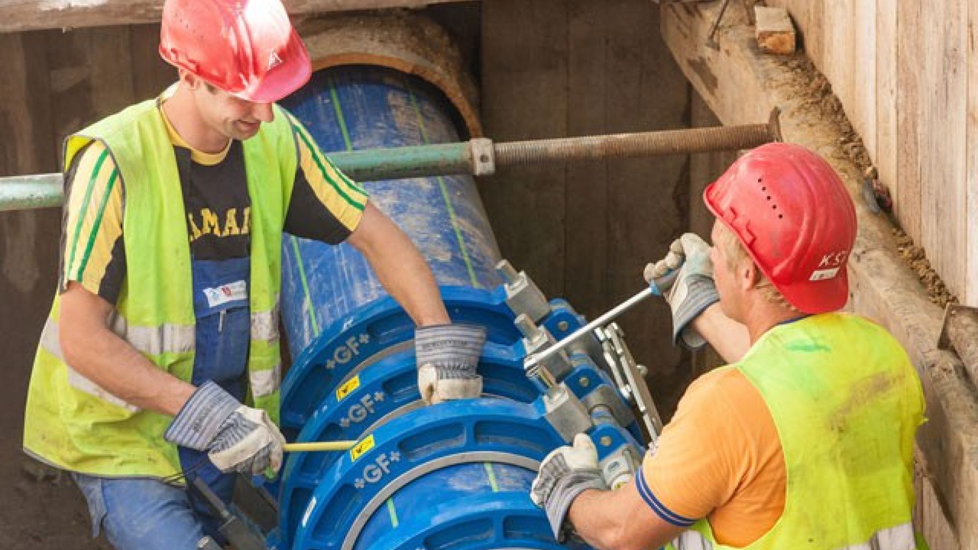 Zwei Mitarbeiter von Wiener Wasser ziehen ein neues Rohr in ein altes Rohr ein