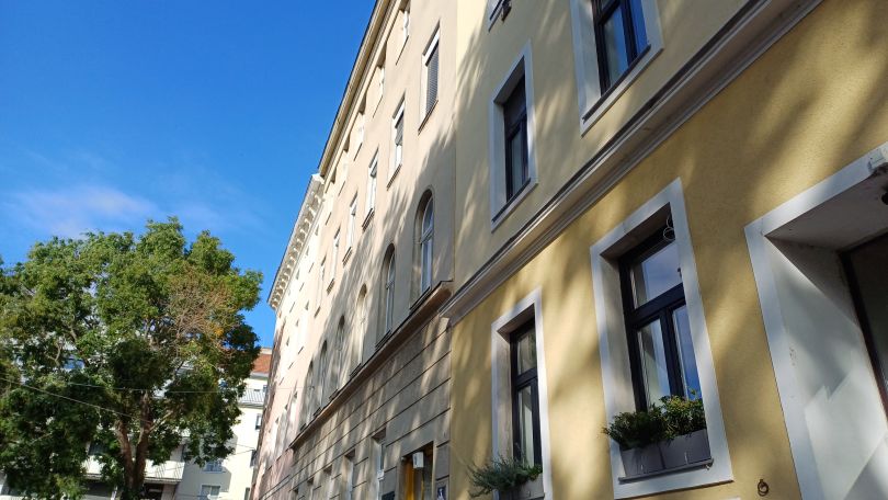 Eine gelbe Hausfassade mit Fenstern