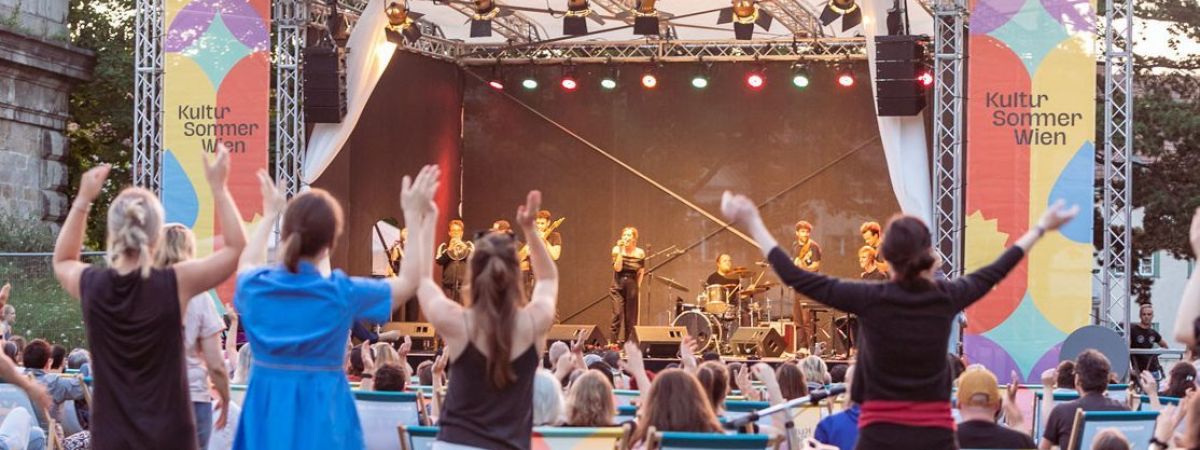 Band spielt auf einer Konzertbühne vor Zuseher*innen