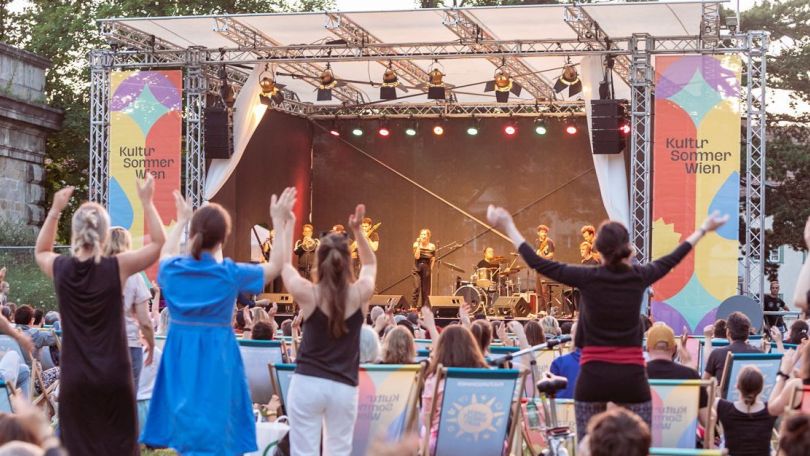 Band spielt auf einer Konzertbühne vor Zuseher*innen
