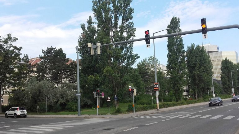 Straßenkreuzung mit Parkanlage im Hintergrund
