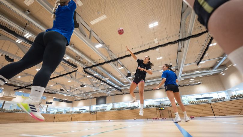 Junge Frauen spielen Handball.