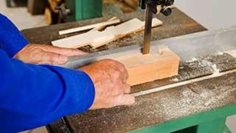 copyright: Erwin Wodicka ein Mann schneidet Holz mit einer elektrischen Holzsäge