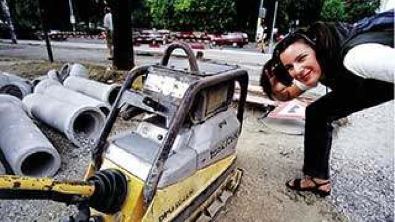 eine Frau steht mit Ohrschützern steht auf einer Baustelle