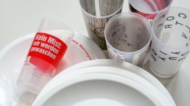 fünf Mehrwegbecher und einige Mehrwegteller