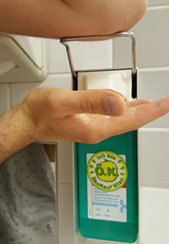 Ein Mann entnimmt Seife aus einem Seifenspender