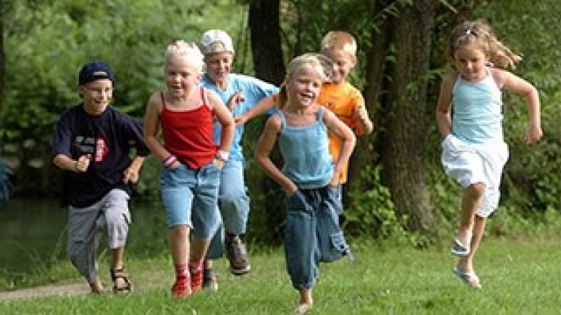 Kinder laufen über eine Wiese