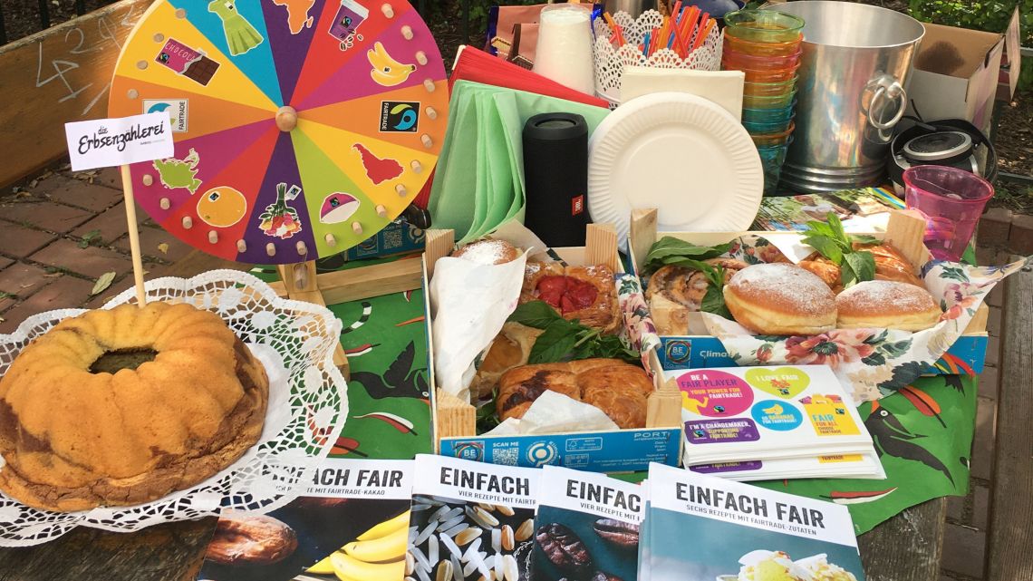 Gedeckter Tisch mit fairen Lebensmitteln und Broschüren über Fairtrade