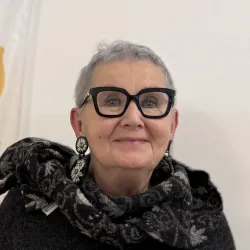 Portrait von einer Frau mit sehr kurzen hellen Haaren und einer großen Brille mit schwarzem Rahmen