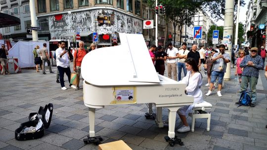 Klavierflügel auf einer Straße mit Zuschauern