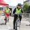 Kinder in gelben Warnwesten und Helm fahren mit dem Rad an einer vorgegebenen Strecke am Übungsplatz