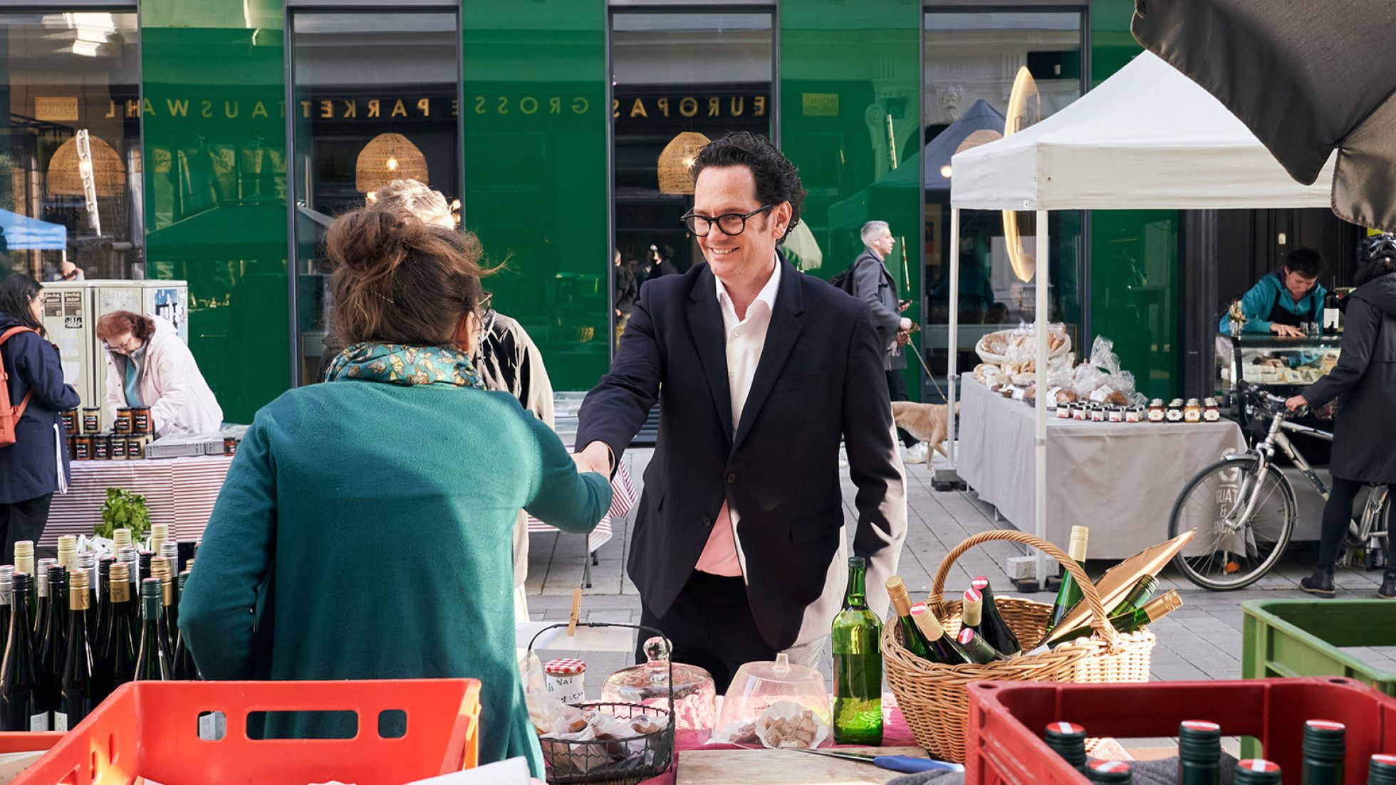 Marktstand mit Standlerin und Kunde