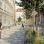 copyright: EGKK Landschaftsarchitektur - Schreiner Kastler Rendering: Eine gepflasterte Begegnungsstraße mit Bäume und Beeten; Kinder spielen auf der Straße; eine Radfahrerin und Passanten sind unterwegs
