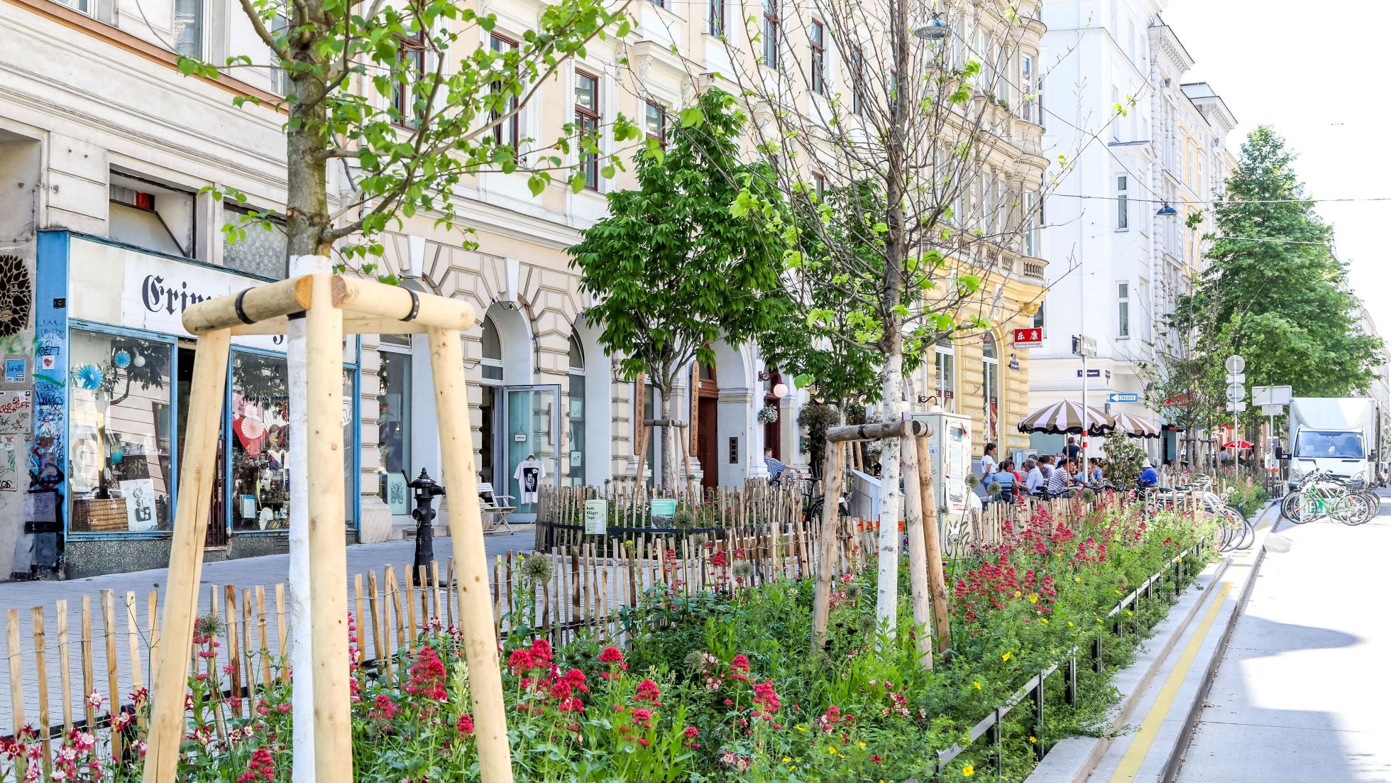 Mit Bäumen und Beeten begrünte Straße und Gehweg