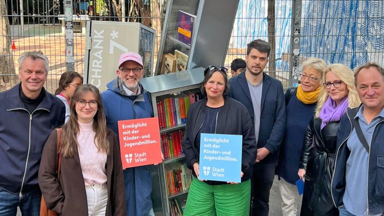 copyright: BV 7 4 Frauen und 4 Männer vor einem Bücherschrank im Freien